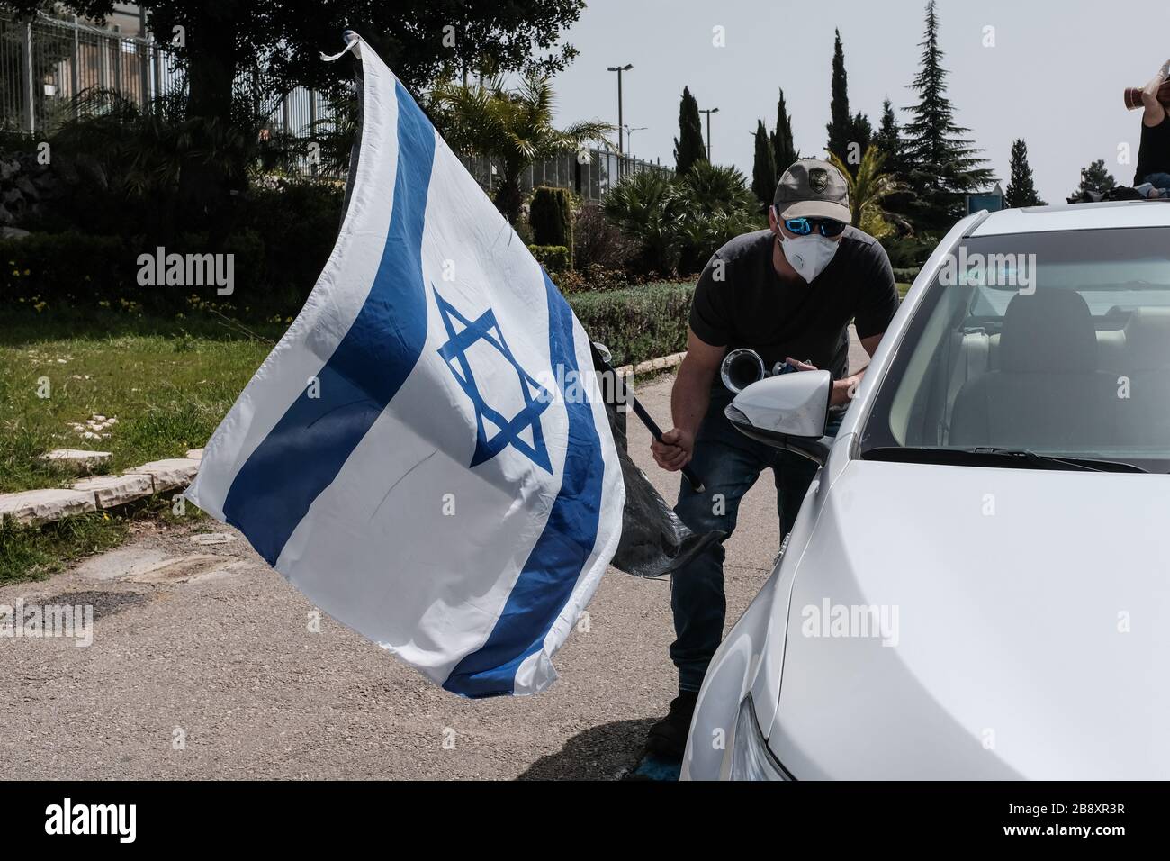 Gerusalemme, Israele. 23 marzo 2020. Il movimento Black Flags porta un convoglio di oltre 1,000 auto alla Knesset, il Parlamento israeliano, sventolando bandiere israeliane e nere, protestando contro il presunto tentativo del governo di Netanyahu di manipolare la legislazione e abusare delle misure di emergenza di Coronavirus nel tentativo di ‘dirottare la democrazia per benefici politici e personali. È in corso un appello della Corte Suprema per ripristinare i pieni poteri del Parlamento, bloccato dal funzionamento del presidente della Knesset, Edelstein, un alleato di Netanyahu. Credit: NIR Alon/Alamy Live News Foto Stock