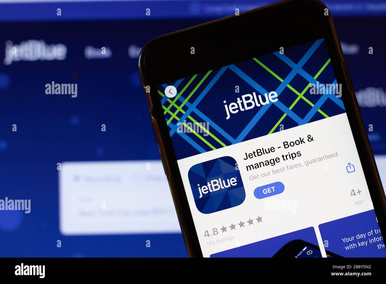 Los Angeles, California, USA - 24 marzo 2020: Logo JetBlue app sullo schermo del telefono primo piano con il sito web sullo sfondo con icona, editoriale illustrativo Foto Stock