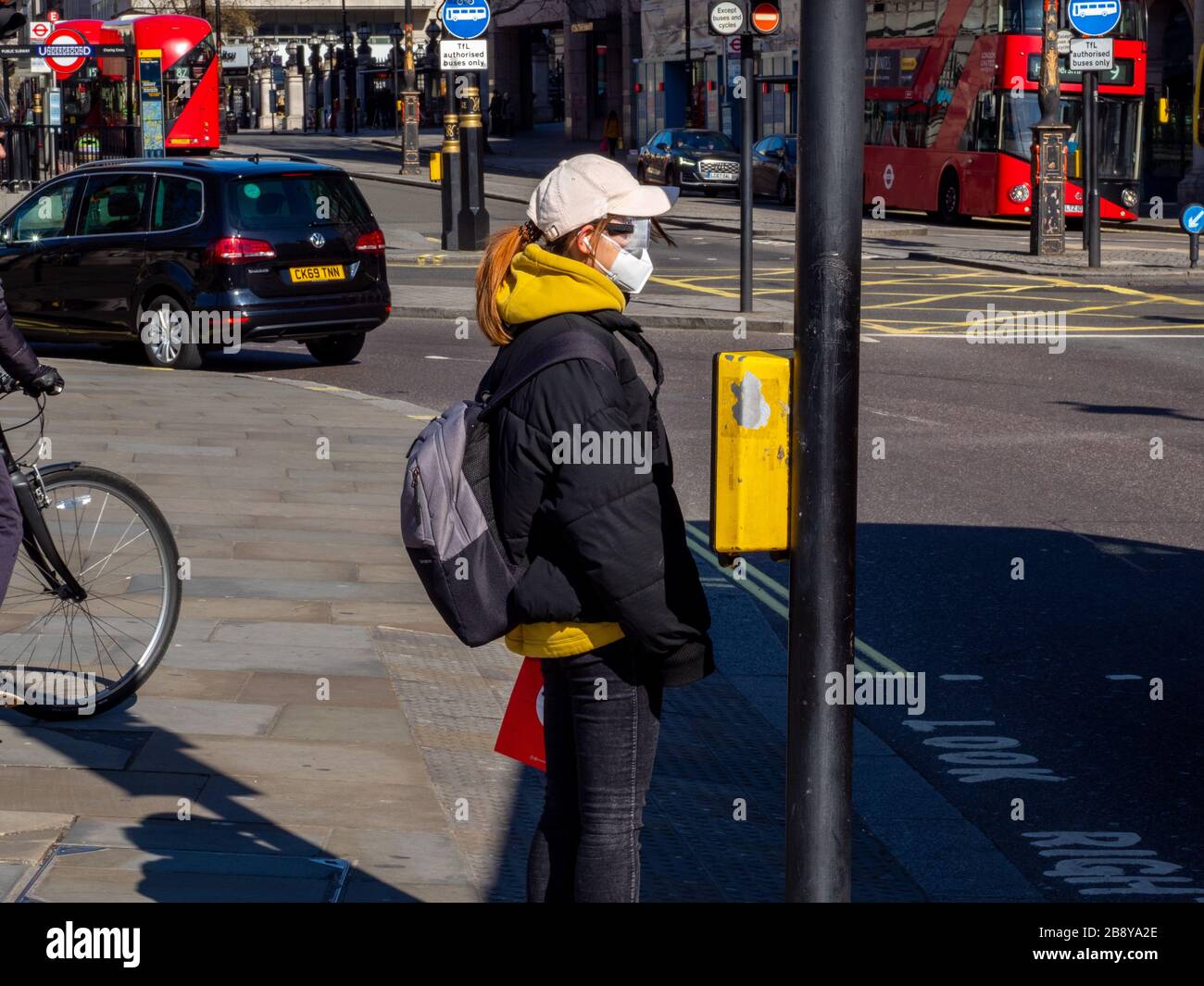 Una donna indossa una maschera protettiva nel centro di Londra durante l'epidemia di coronavirus. Foto Stock