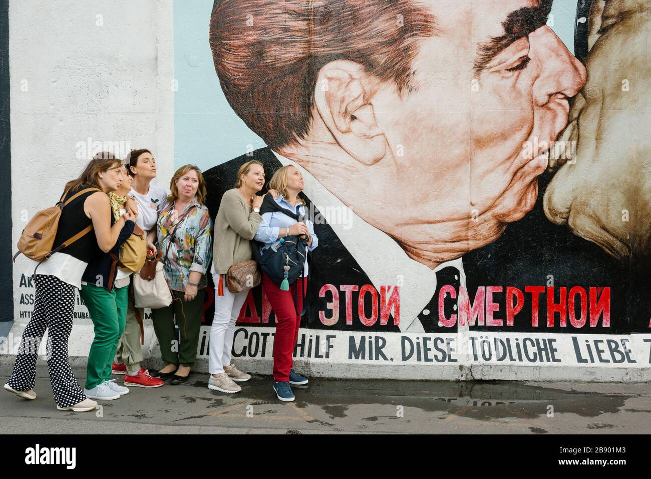 Turisti che scattano foto al dipinto murale 'fraterno Kiss' di Dmitri Vrubel. Berlino, Germania Foto Stock