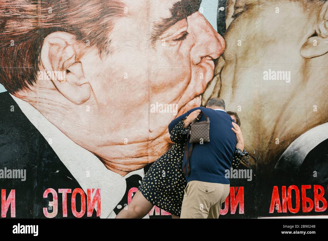 Turisti che scattano foto al dipinto murale 'fraterno Kiss' di Dmitri Vrubel. Berlino, Germania Foto Stock