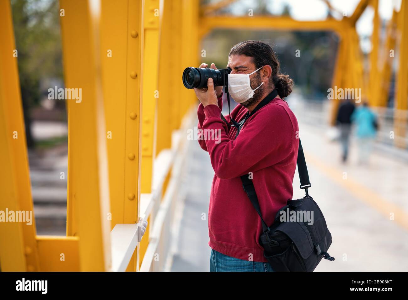 Un fotografo giornalista spara a persone incoscienti su strade affollate con una maschera in un periodo di quarantena a causa di pandemico pericolo globale Foto Stock
