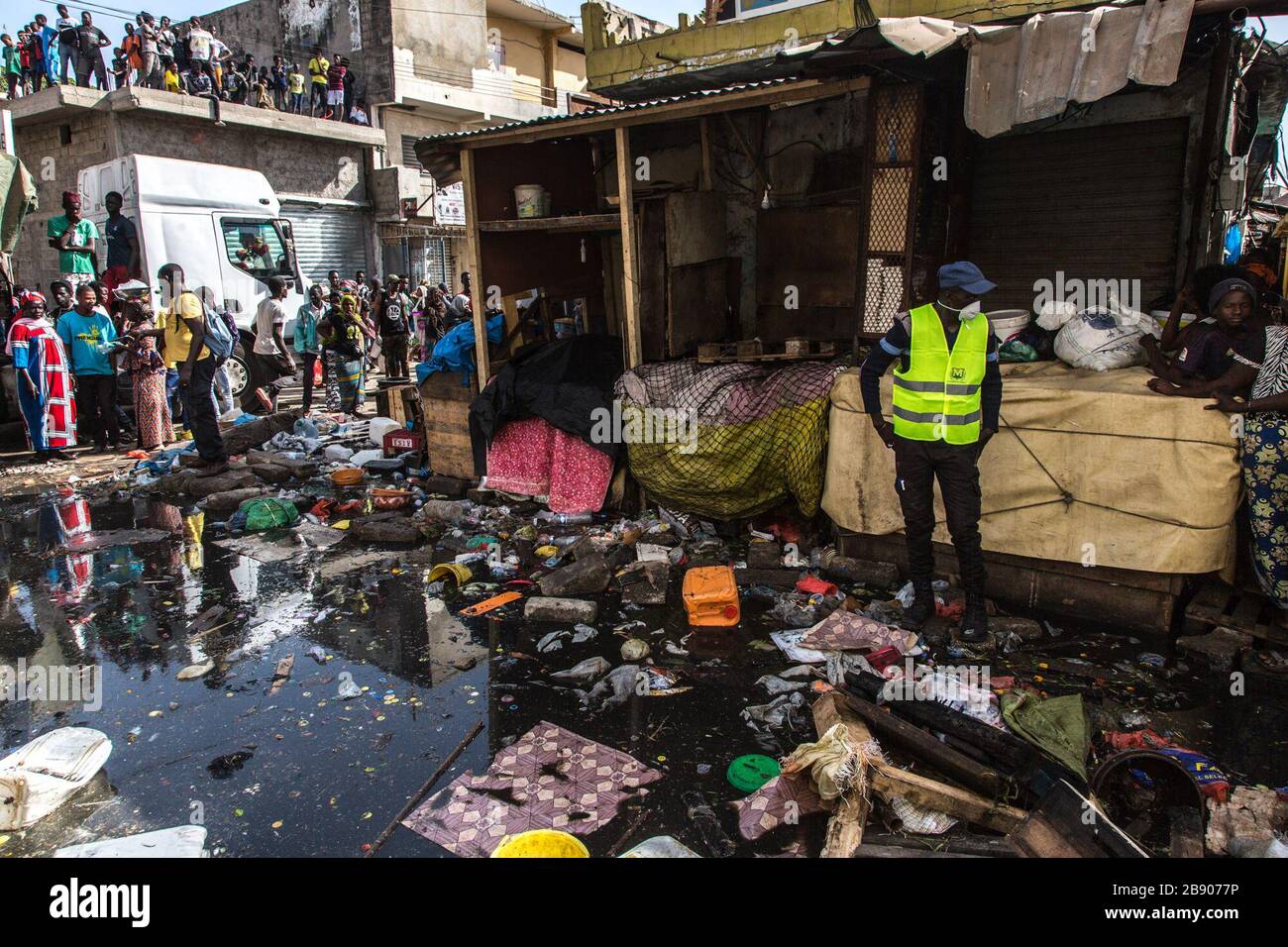 (200323) -- DAKAR, 23 marzo 2020 (Xinhua) -- la gente guarda la disinfezione del mercato di Tilene nel distretto di Medina, Dakar, Senegal, 22 marzo 2020. Per migliorare le condizioni sanitarie e ridurre la diffusione della COVID-19, il governo senegalese ha ordinato di pulire alcune zone che rappresentano minacce sanitarie nelle città. Finora il Senegal ha riportato 67 casi di infezione da COVID-19. (Foto di Eddy Peters/Xinhua) Foto Stock