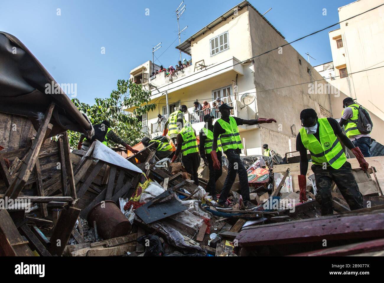 (200323) -- DAKAR, 23 marzo 2020 (Xinhua) -- i lavoratori della città camminano sopra i rifiuti dopo aver demolito i negozi illegali del mercato all'aperto di Tilene a Dakar, Senegal, 22 marzo 2020. Per migliorare le condizioni sanitarie e ridurre la diffusione della COVID-19, il governo senegalese ha ordinato di pulire alcune zone che rappresentano minacce sanitarie nelle città. Finora il Senegal ha riportato 67 casi di infezione da COVID-19. (Foto di Eddy Peters/Xinhua) Foto Stock