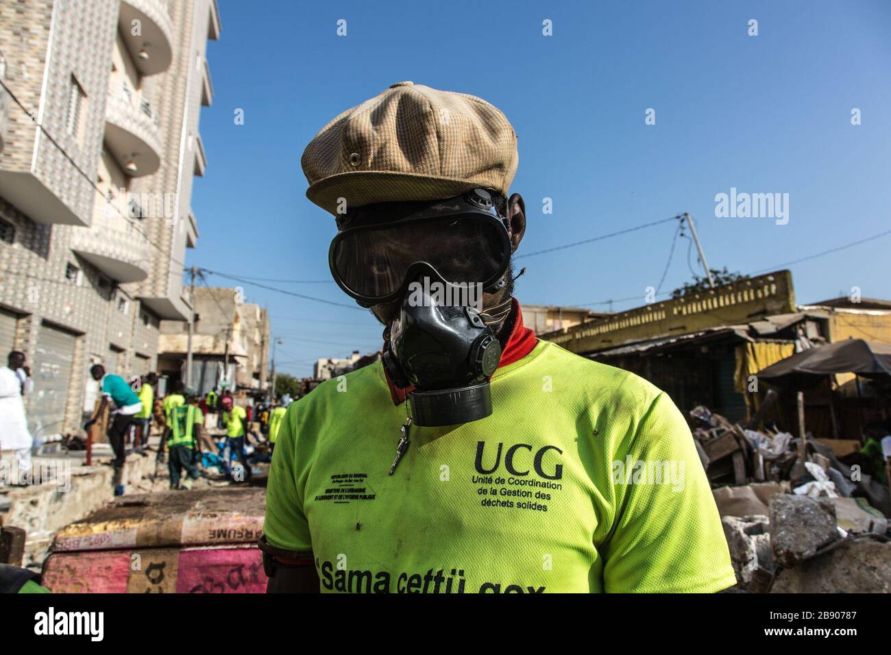 (200323) -- DAKAR, 23 marzo 2020 (Xinhua) -- un membro della Solid Waste Management Coordination Unit (UCG) è visto indossare una maschera a gas mentre demolisce i negozi illegali nel mercato all'aperto di Tilene e la disinfetta a Dakar, Senegal, 22 marzo 2020. Per migliorare le condizioni sanitarie e ridurre la diffusione della COVID-19, il governo senegalese ha ordinato di pulire alcune zone che rappresentano minacce sanitarie nelle città. Finora il Senegal ha riportato 67 casi di infezione da COVID-19. (Foto di Eddy Peters/Xinhua) Foto Stock