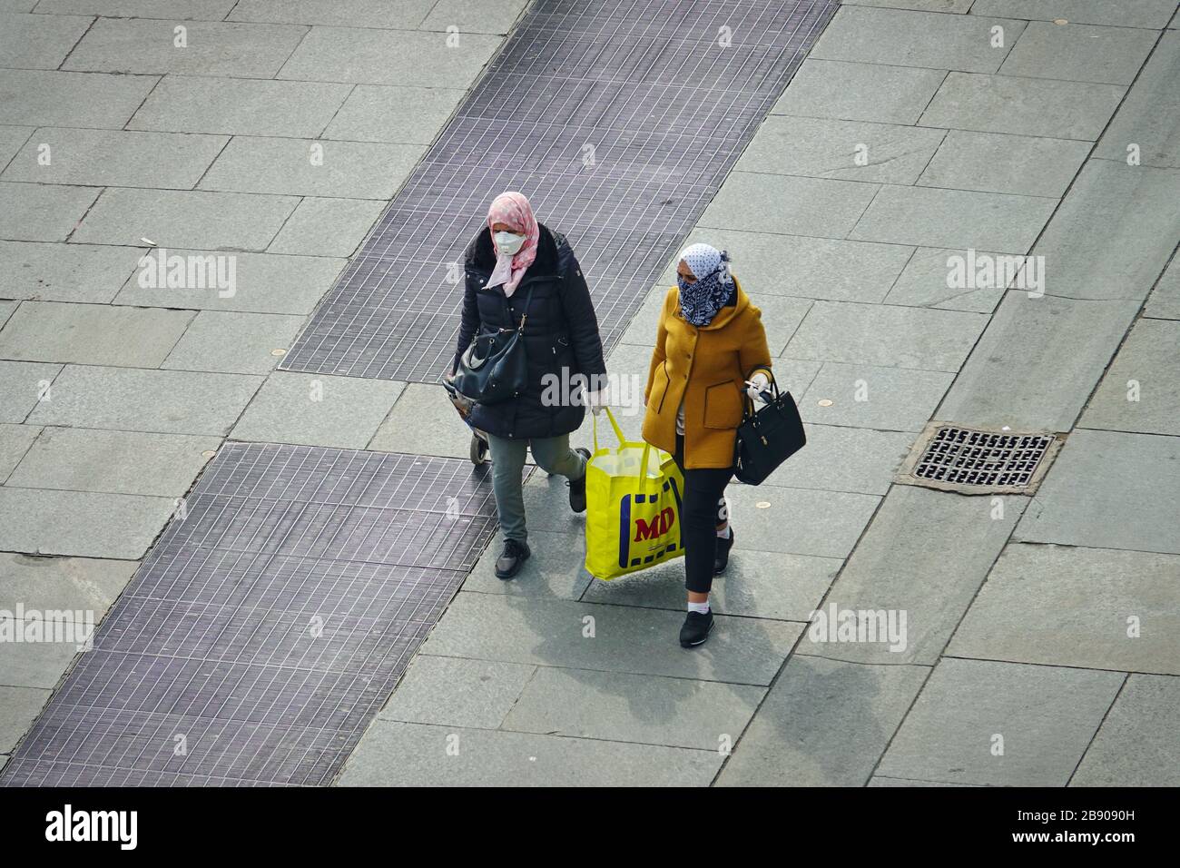 La gente di nuovo dallo shopping che indossa le maschere per contenere la diffusione di Coronavirus. Milano, Italia - Marzo 2020 Foto Stock
