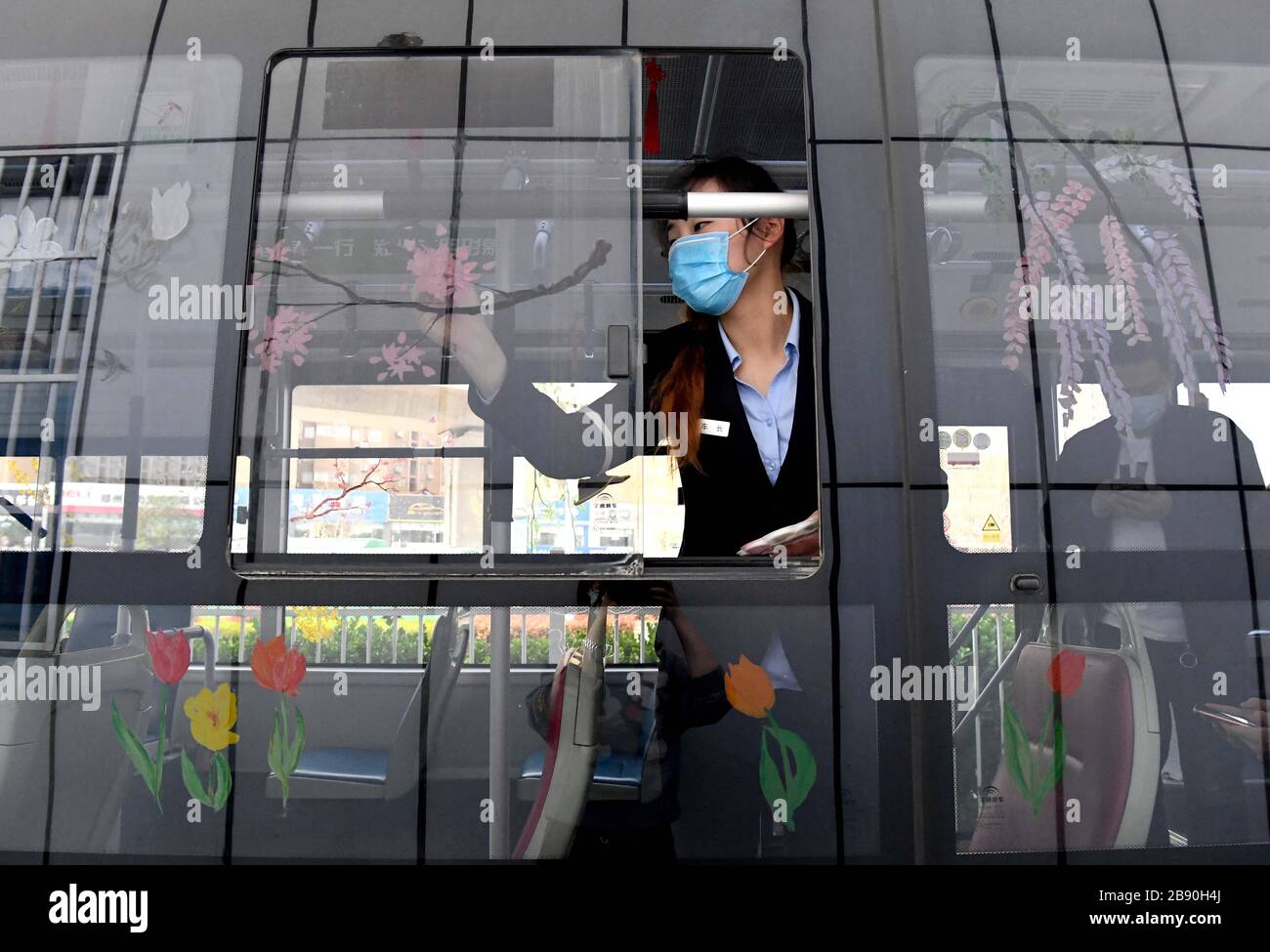 (200323) -- ZHENGZHOU, 23 marzo 2020 (Xinhua) -- Liu Xiangjie attrae fiori sulla finestra degli autobus di Zhengzhou, provincia di Henan della Cina centrale, 23 marzo 2020. Liu Xiangjie lavora come conduttore di autobus della linea S105 gestita dalla Zhengzhou Bus Communication Corporation. Ha dipinto modelli di fiori sulla finestra degli autobus di recente come la primavera viene. (Xinhua/li AN) Foto Stock