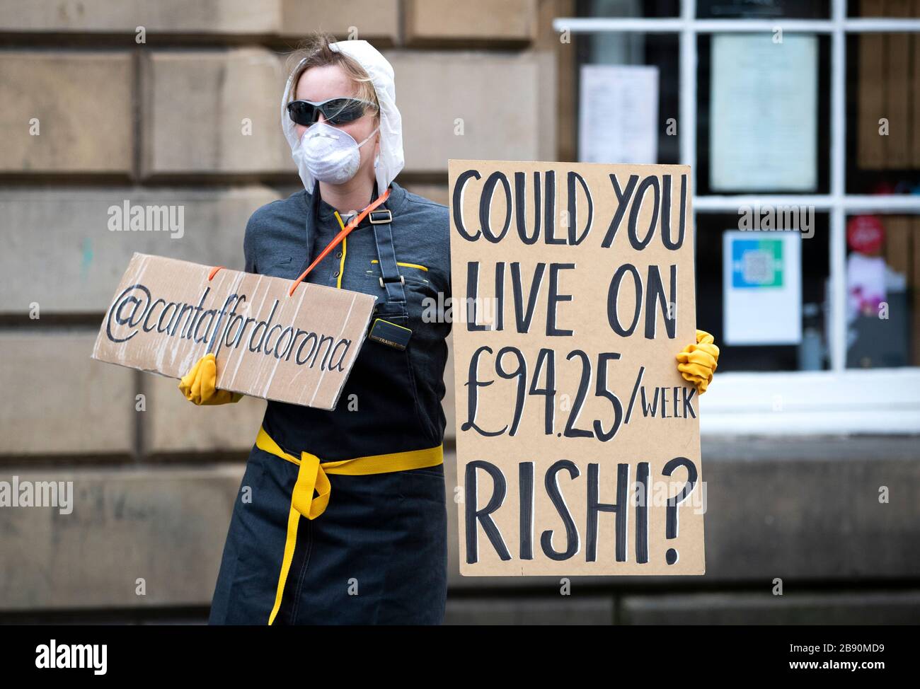 Un dimostratore protesta circa il governo britannico indennità di paga per malattia di £94 alla settimana per i lavoratori freelance e autonomi durante l'epidemia di coronavirus sul Royal Mile, Edimburgo. Foto Stock