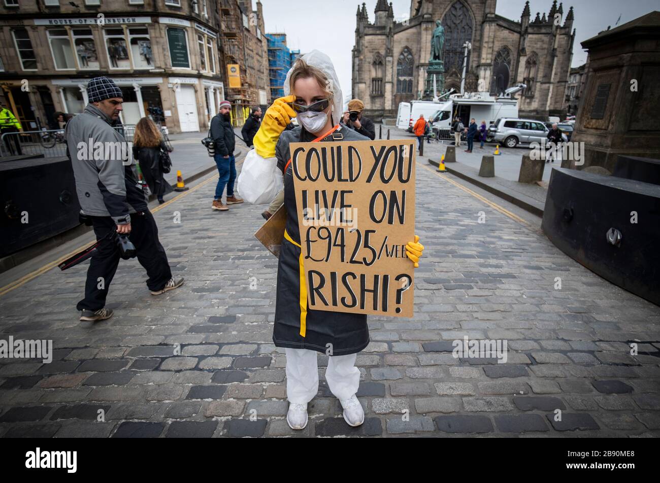 Un dimostratore protesta circa il governo britannico indennità di paga per malattia di £94 alla settimana per i lavoratori freelance e autonomi durante l'epidemia di coronavirus sul Royal Mile, Edimburgo. Foto Stock
