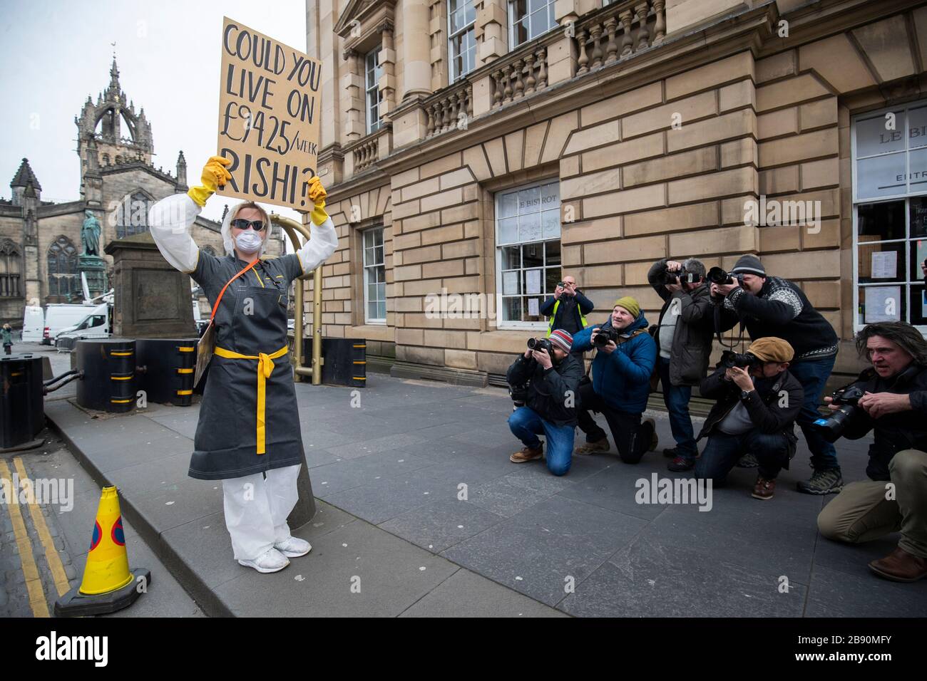 Un dimostratore protesta circa il governo britannico indennità di paga per malattia di £94 alla settimana per i lavoratori freelance e autonomi durante l'epidemia di coronavirus sul Royal Mile, Edimburgo. Foto Stock