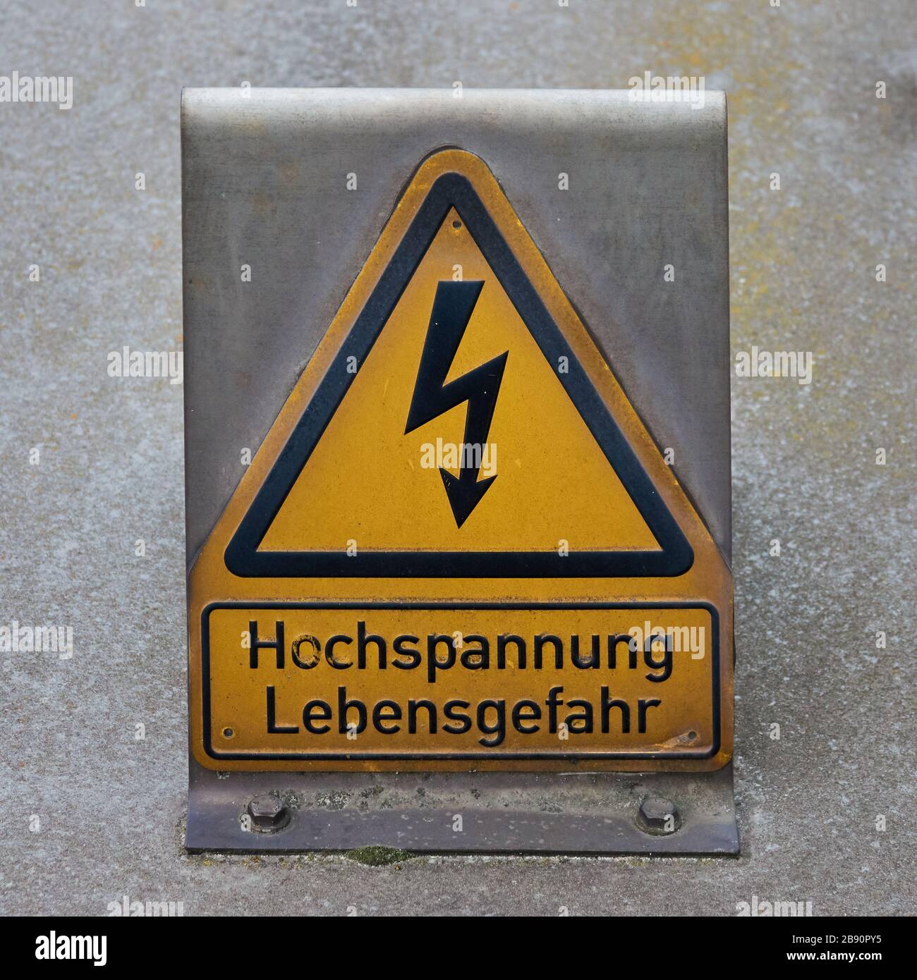 Simbolo di avvertimento giallo con un fulmine stilizzato e l'iscrizione tedesca: Alta tensione, pericolo di vita Foto Stock