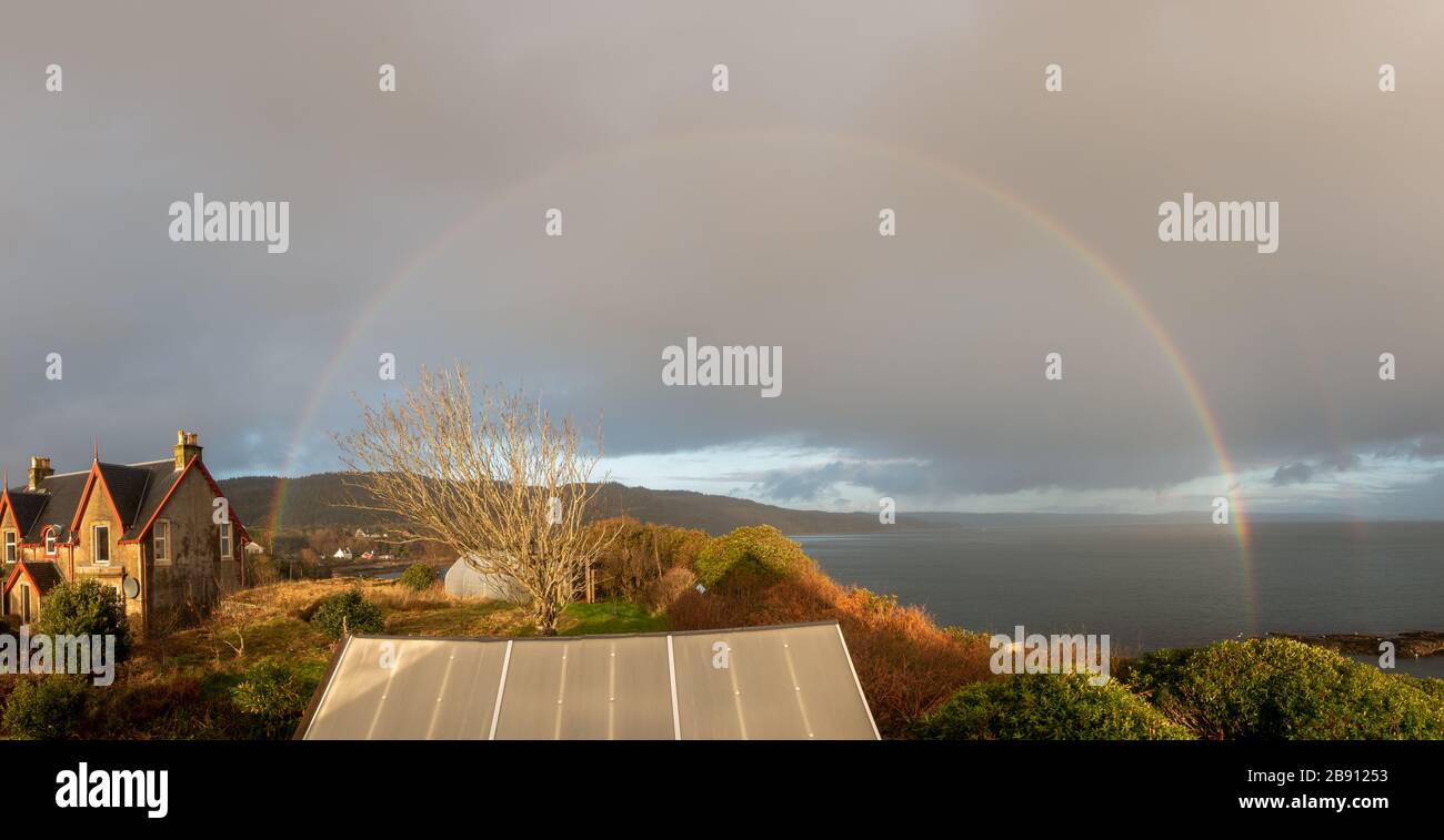 Arcobaleno sopra il villaggio di Carradale, Kintyre, Argyll e Bute, Scozia Foto Stock