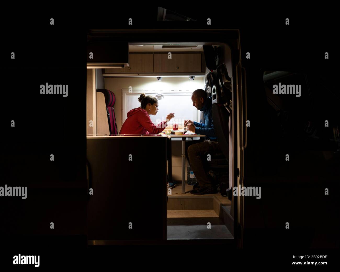 Coppia con una cena rilassante in un camper durante un viaggio. Foto Stock