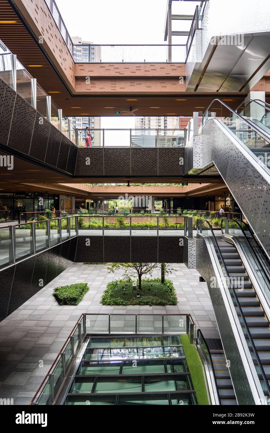 SHANGHAI, CINA - 10 NOVEMBRE 2018. Centro commerciale Ruihong Tiandi. Cortile esterno di un complesso di vendita al dettaglio con scalatori. Giardino con passerella e. Foto Stock