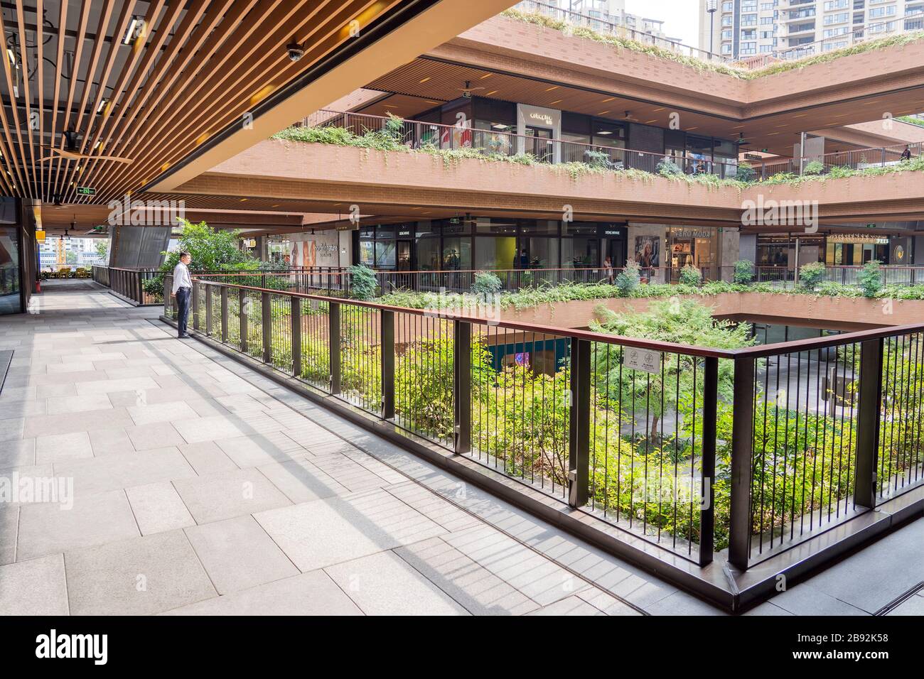 SHANGHAI, CINA - 10 NOVEMBRE 2018. Centro commerciale Ruihong Tiandi. Cortile esterno di un complesso di negozi con vegetazione lussureggiante. Giardino con passerella a Foto Stock