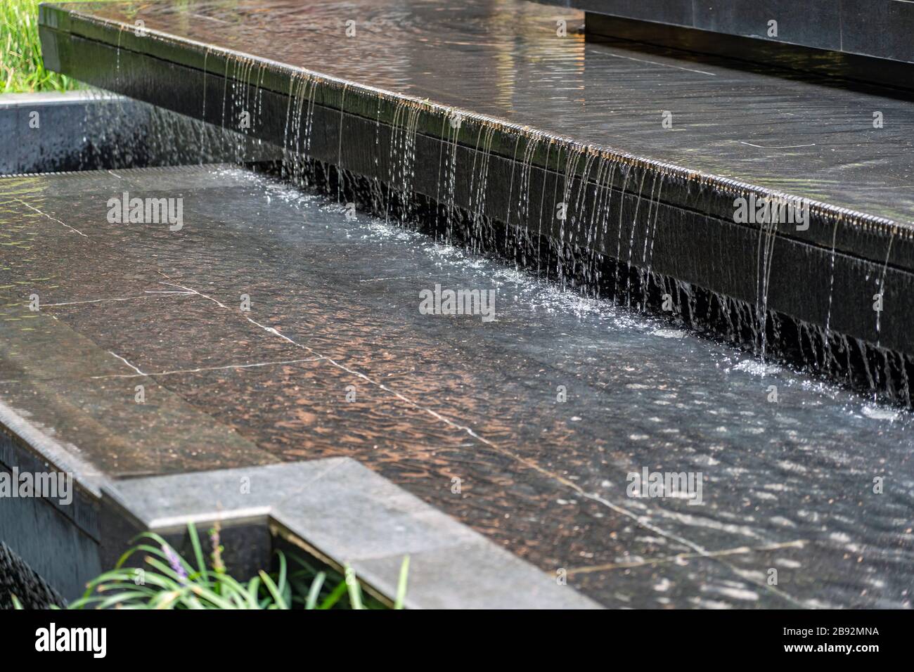 Piccola cascata nel cortile all'aperto. Water Feature come parte del Landscape Design. Foto Stock