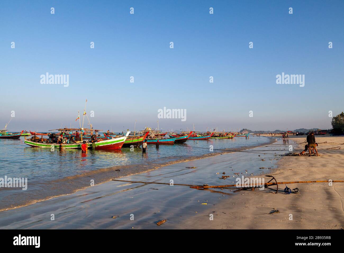 Il pescato mattutino è arrivato al villaggio di pescatori di Ngapali. Il pesce viene portato a terra e diviso o venduto. Ngapali, Stato di Rakhine, Myanmar. Foto Stock