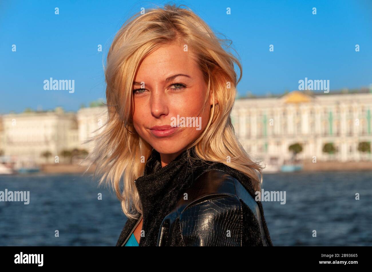 Giovane donna attraente sull'argine del fiume Neva, San Pietroburgo, Russia Foto Stock