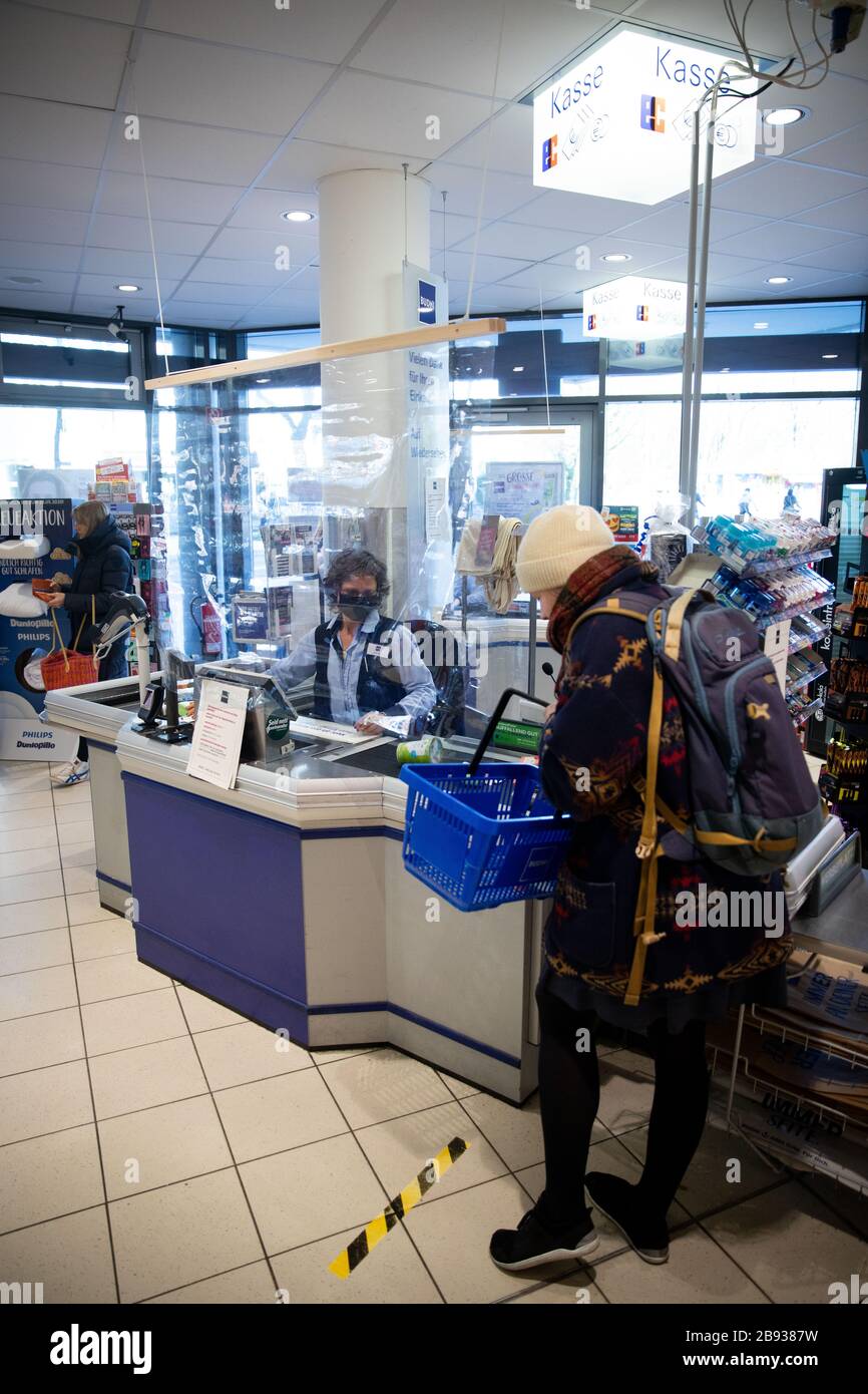 Amburgo, Germania. 23 marzo 2020. Misure di protezione temporanee proteggono i cassieri di una succursale della catena di farmacia Budni. In molte filiali di Aldi, Lidl, Netto, Rewe, Penny e altri supermercati e farmacie, i pannelli in plexiglas e altri dispositivi sono attualmente installati come 'protezione dei pita' presso i registratori di cassa, secondo un sondaggio tra supermercati e catene di discount store da parte dell'Agenzia Stampa tedesca. Per rallentare la diffusione del virus corona, il governo federale ha ulteriormente limitato considerevolmente la vita pubblica. Il nuovo coronavirus viene trasmesso principalmente mediante infezione da goccioline. PH Foto Stock