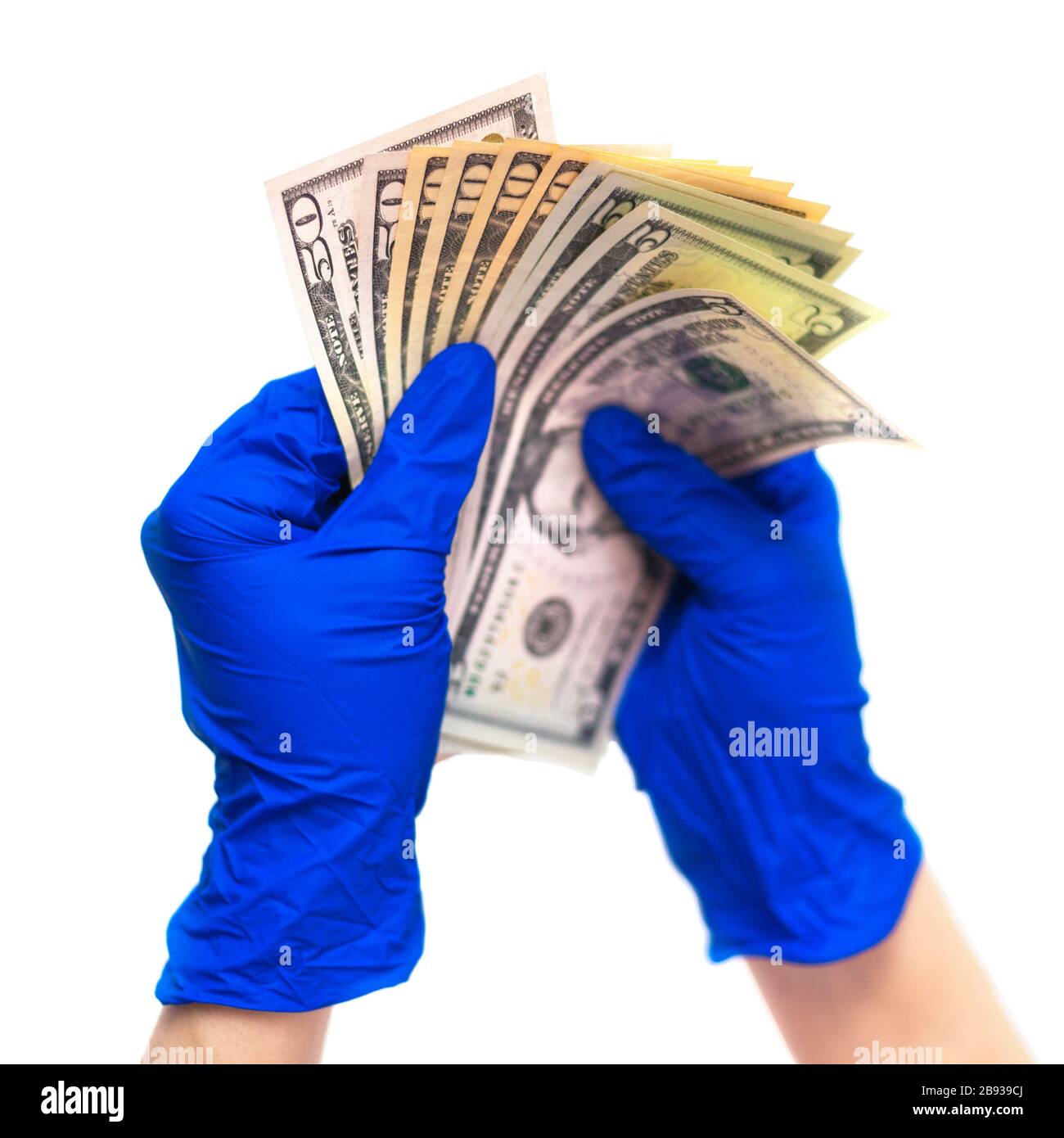 Mani in guanti per uso medico in possesso di un pacchetto di dollari. Il concetto di infezione su soldi, soldi sporchi, medicina paid, tasse di trattamento, tangenti, chirurgia illegale. Foto Stock
