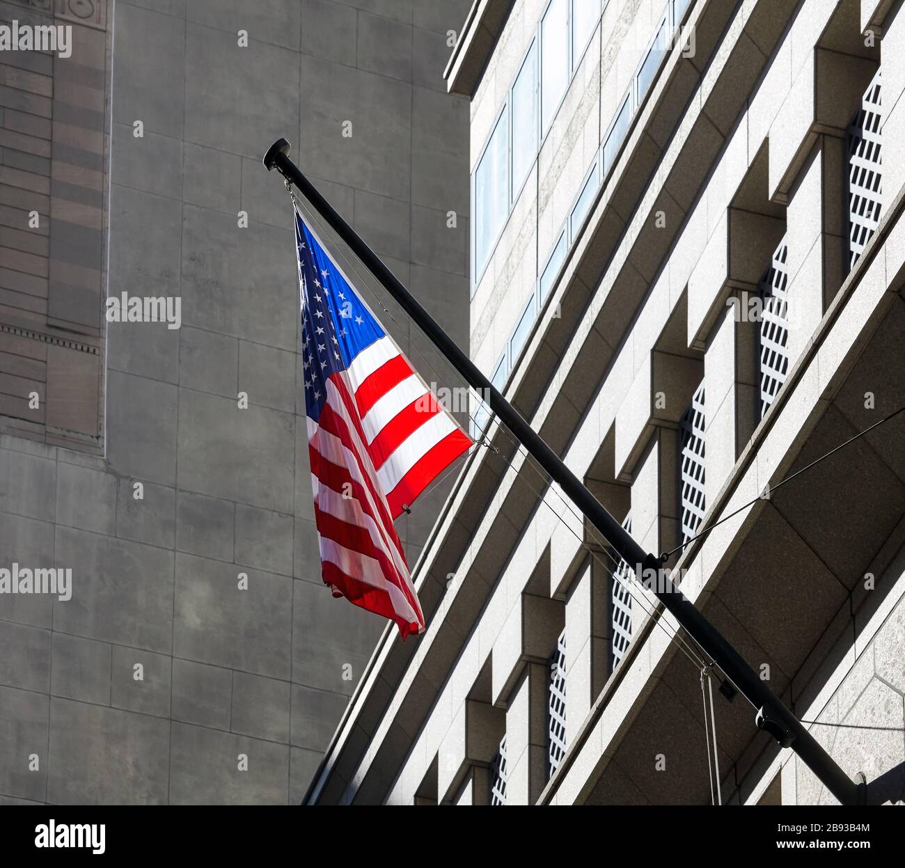 Bandiera americana con facciata edificio sullo sfondo, New York City, USA. Foto Stock