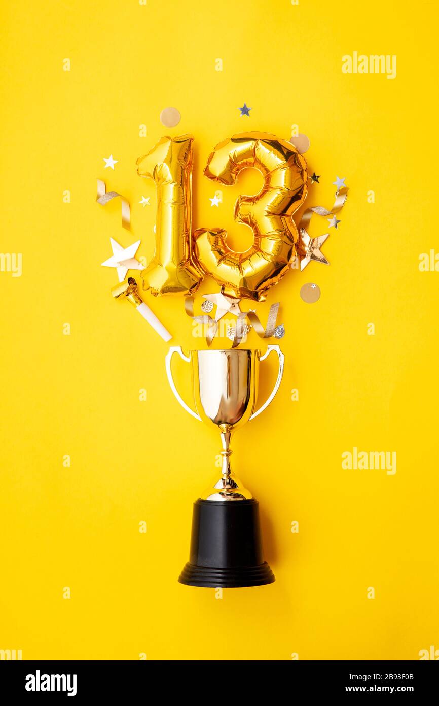 Palloncino numero 13 per la celebrazione dell'anniversario d'oro che esplode da un trofeo vincente Foto Stock