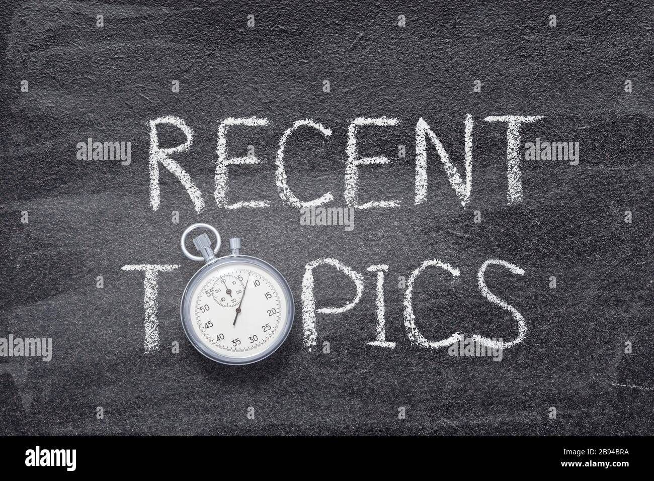 Argomenti recenti frase scritta a mano su lavagna con cronometro vintage preciso utilizzato al posto di o Foto Stock