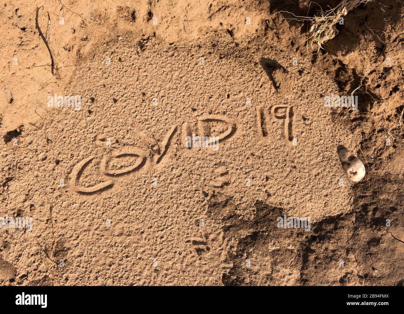 Nome del coronavirus scritto in sabbia Foto Stock