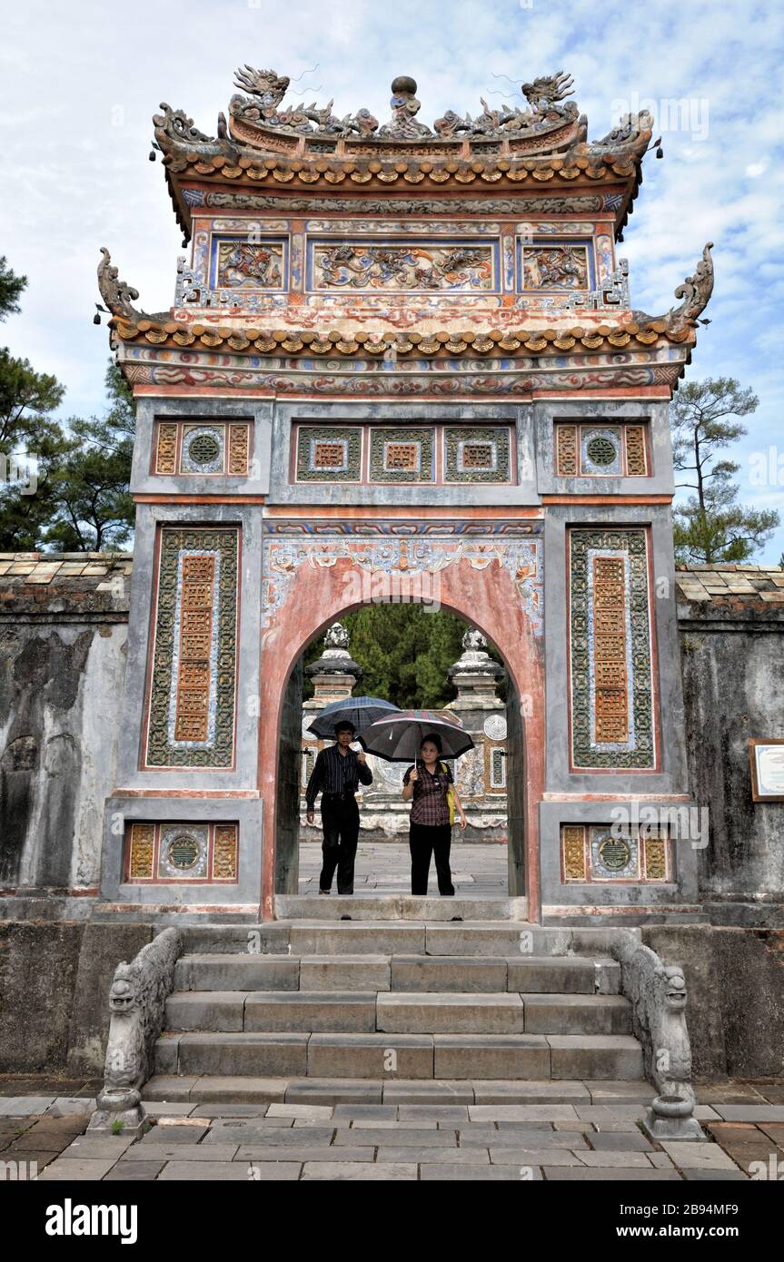 Coppia alla porta della tomba di Tu Duc, Hue, Vietnam Foto Stock