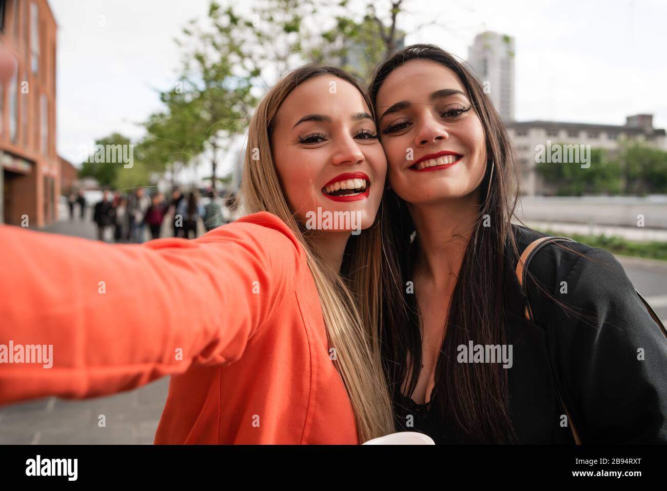 Ritratto di due giovani amici che prendono un selfie all'aperto in strada. Stili di vita e concetti di amicizia. Foto Stock