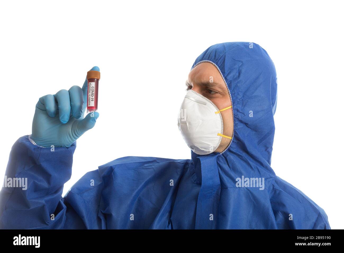 Medico in abbigliamento protettivo che guarda il campione di sangue Foto Stock