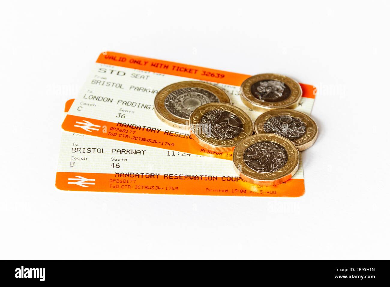 Due biglietti del treno (da Bristol Parkway a Londra Paddington) e monete britanniche su sfondo bianco Foto Stock
