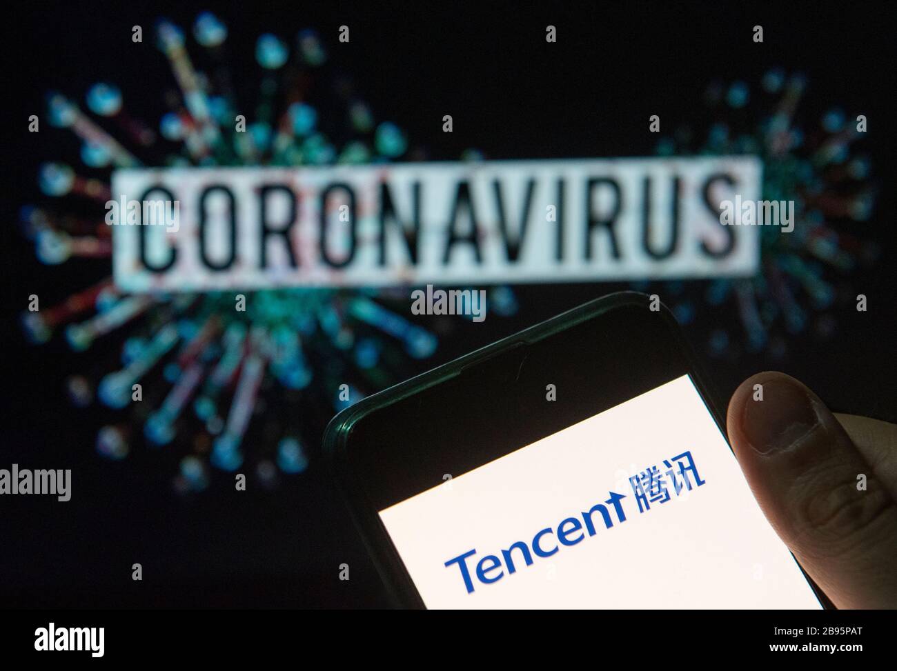 In questa illustrazione della foto il logo Tencent del conglomerato multinazionale cinese di investimento visualizzato su uno smartphone con un modello di computer del coronavirus COVID-19 sullo sfondo. Foto Stock