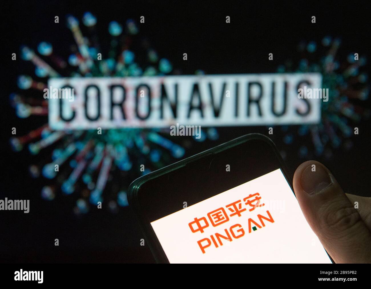 In questa illustrazione della foto il logo cinese del gruppo di aziende di assicurazione Ping a visto visualizzato su uno smartphone con un modello di computer del coronavirus COVID-19 sullo sfondo. Foto Stock