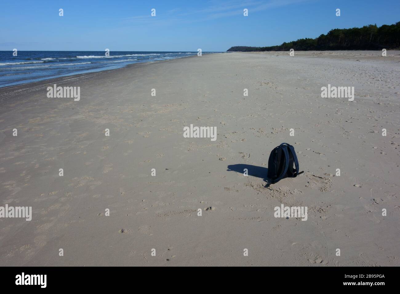 Zaino perso su una spiaggia vuota, paesaggio Foto Stock