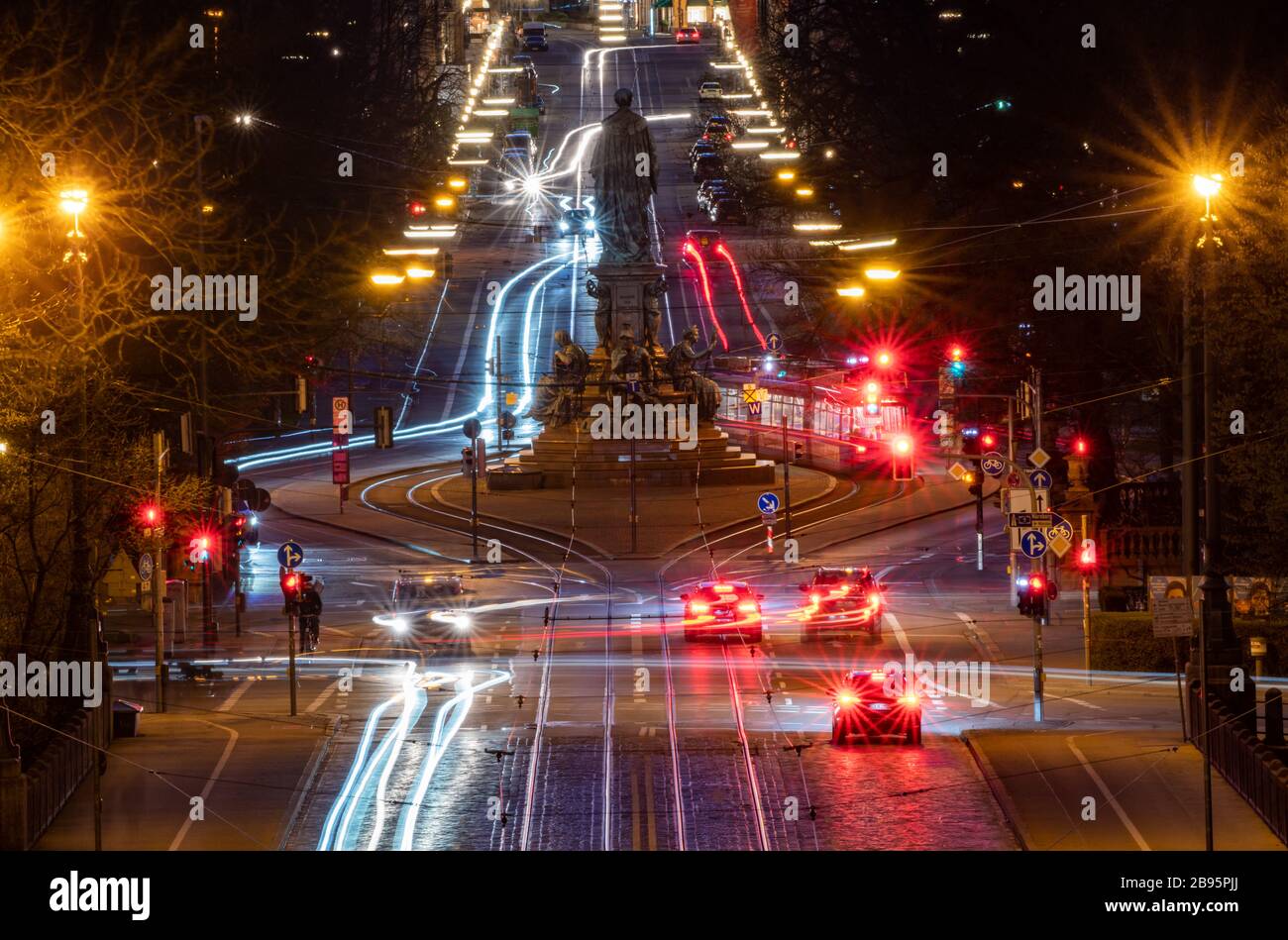 Monaco, Germania. 23 marzo 2020. Traffico notturno su Maximilianstraße intorno al Maxmonument. Il monumento fu eretto dopo la morte del re bavarese Max II nel 1864. Il viale è uno dei negozi più nobili della capitale bavarese. (Scatto con esposizione lunga di 30 secondi) Credit: Peter Kneffel/dpa/Alamy Live News Foto Stock