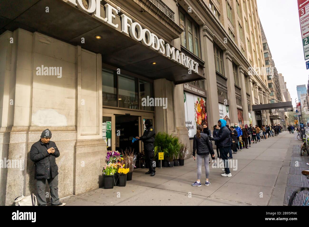 Line of customers outside of Whole Foods Market in Chelsea a New York, in quanto il negozio limita la quantità di acquirenti all'interno a causa della pandemia COVID-19, vista sabato 21 marzo 2020. (© Richard B. Levine) Foto Stock