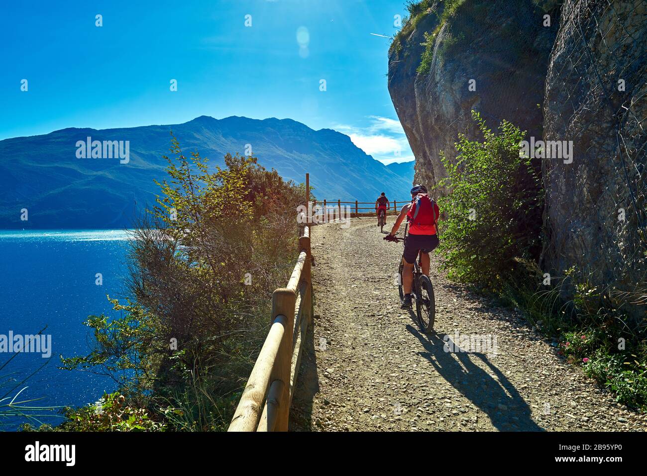 Ciclisti in bicicletta lungo la via ponale a Riva del Garda Foto Stock