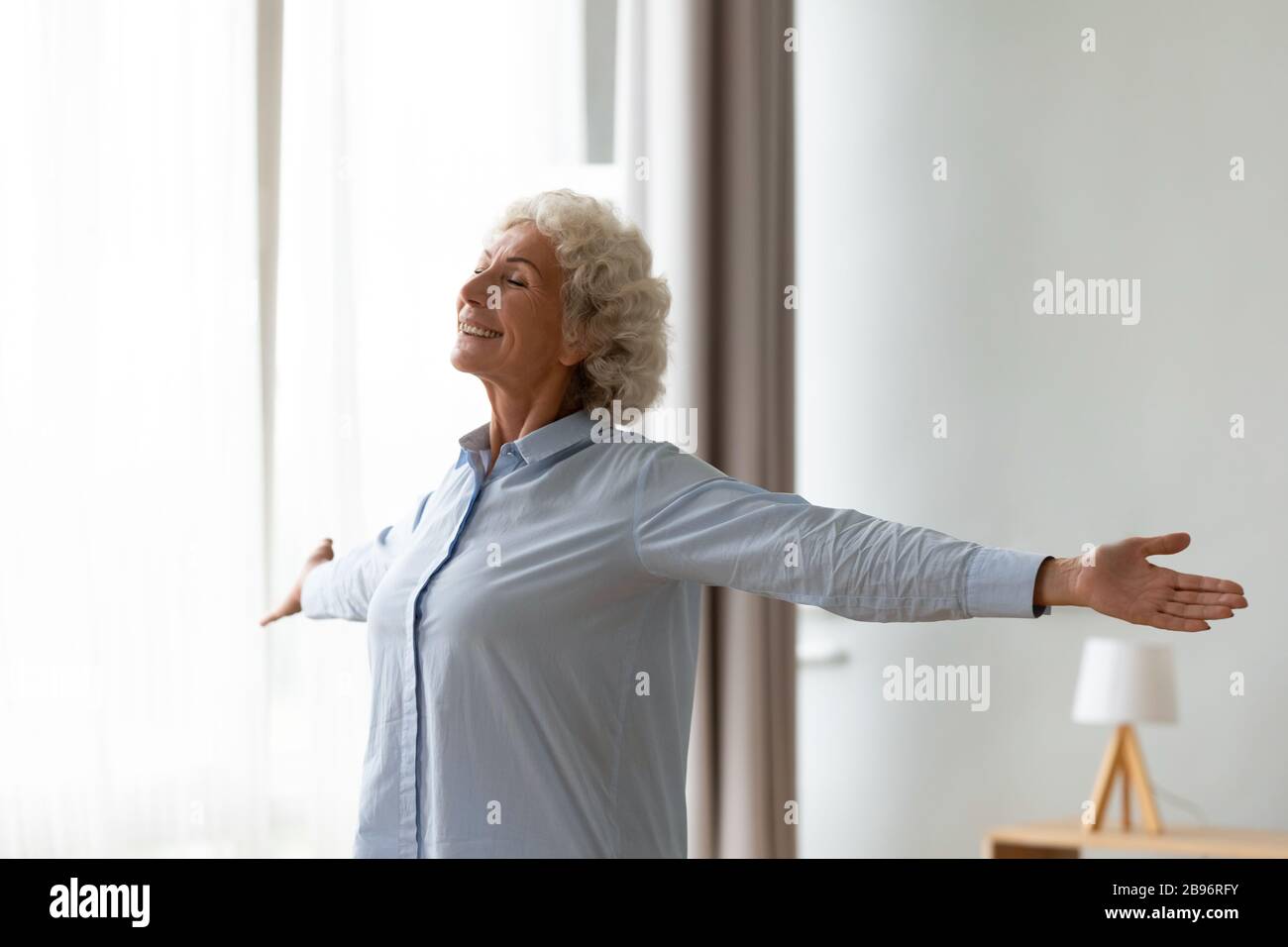 Stretching della vecchia donna overjoyed a casa sensibilità positiva Foto Stock