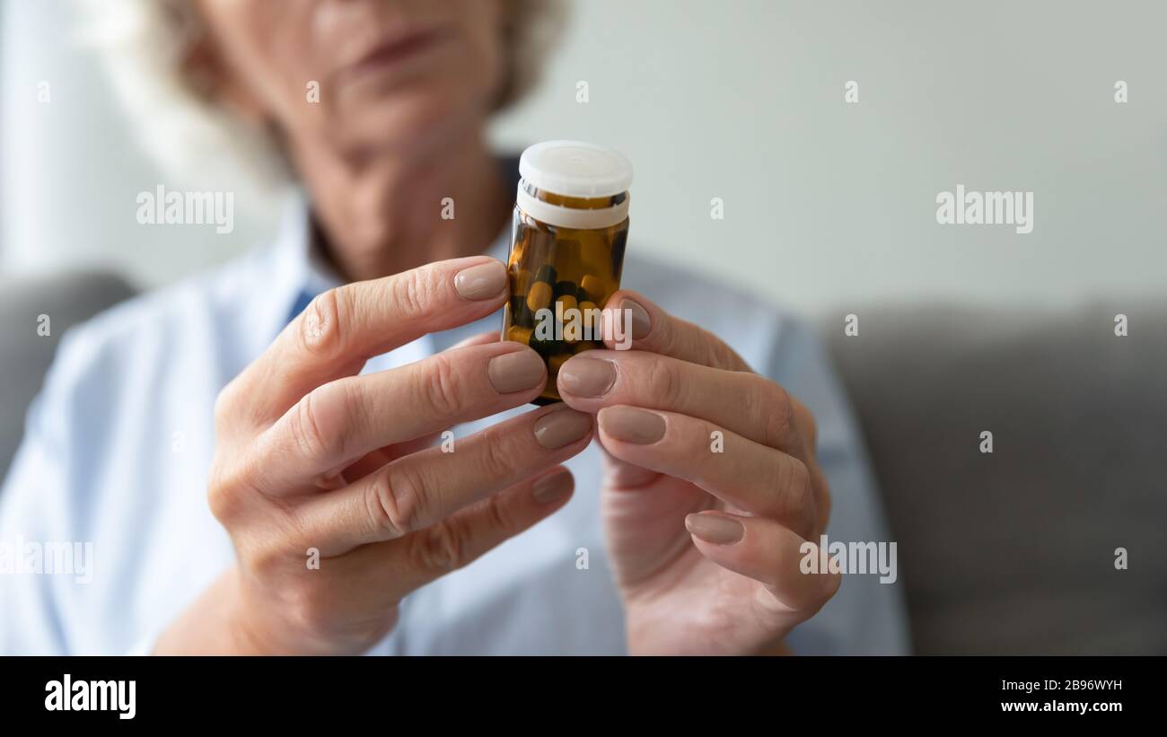 Primo piano della donna anziana che prende i medicinali prescritti a casa Foto Stock