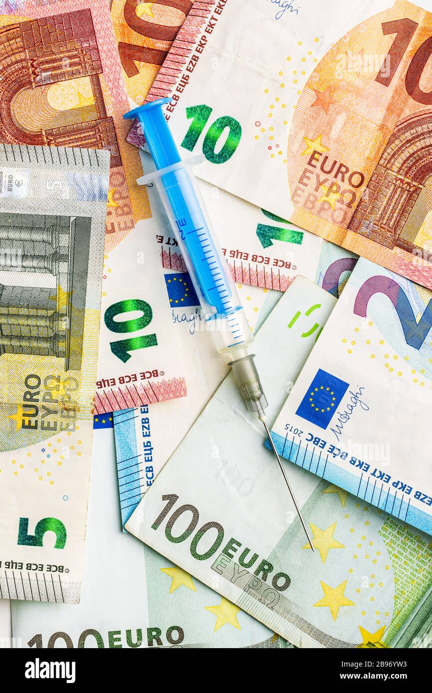 Siringa e denaro in euro. Concetto di assistenza sanitaria. Vista dall'alto. Foto Stock