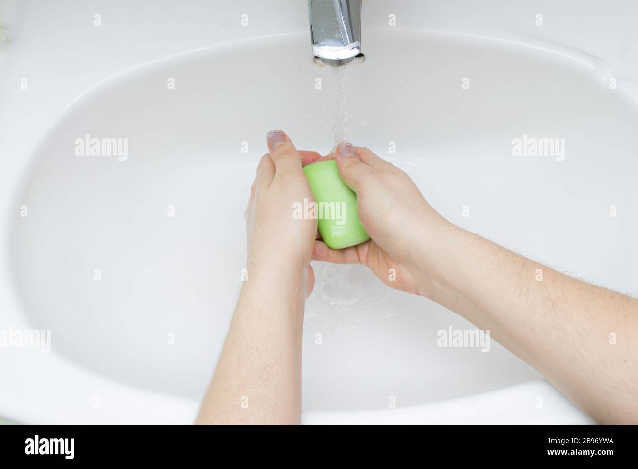 Concetto di igiene. Lavare le mani con acqua e sapone sotto il rubinetto Foto Stock