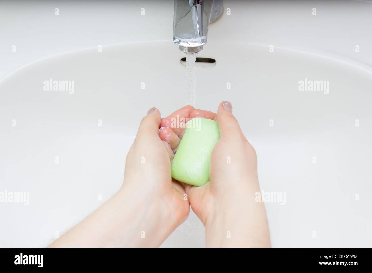Primo piano su donna giovane lavando le mani con sapone. Foto Stock