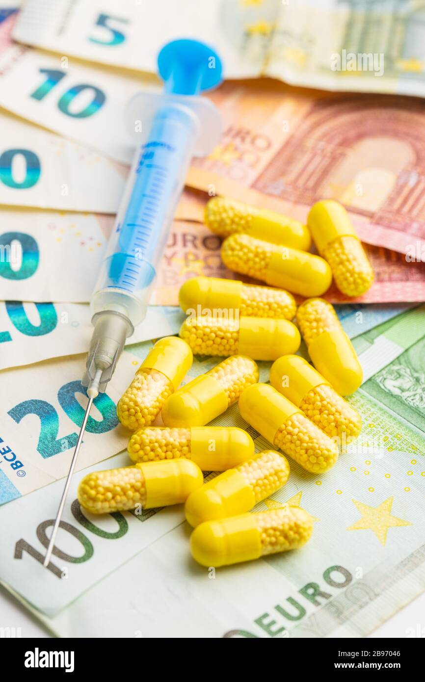 Siringa, pillole e euro denaro. Concetto sanitario e aziendale. Foto Stock