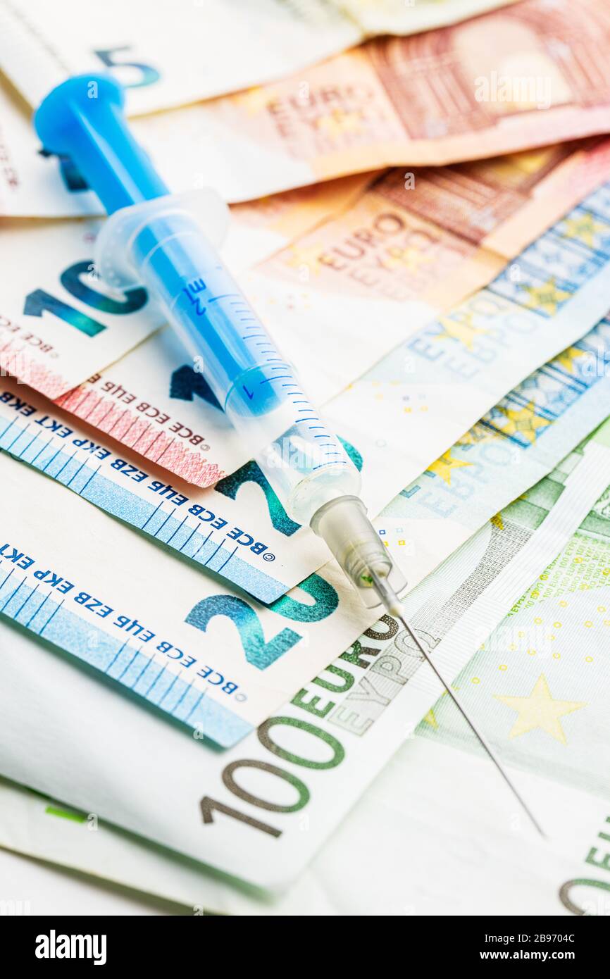 Siringa e denaro in euro. Concetto sanitario e aziendale. Foto Stock