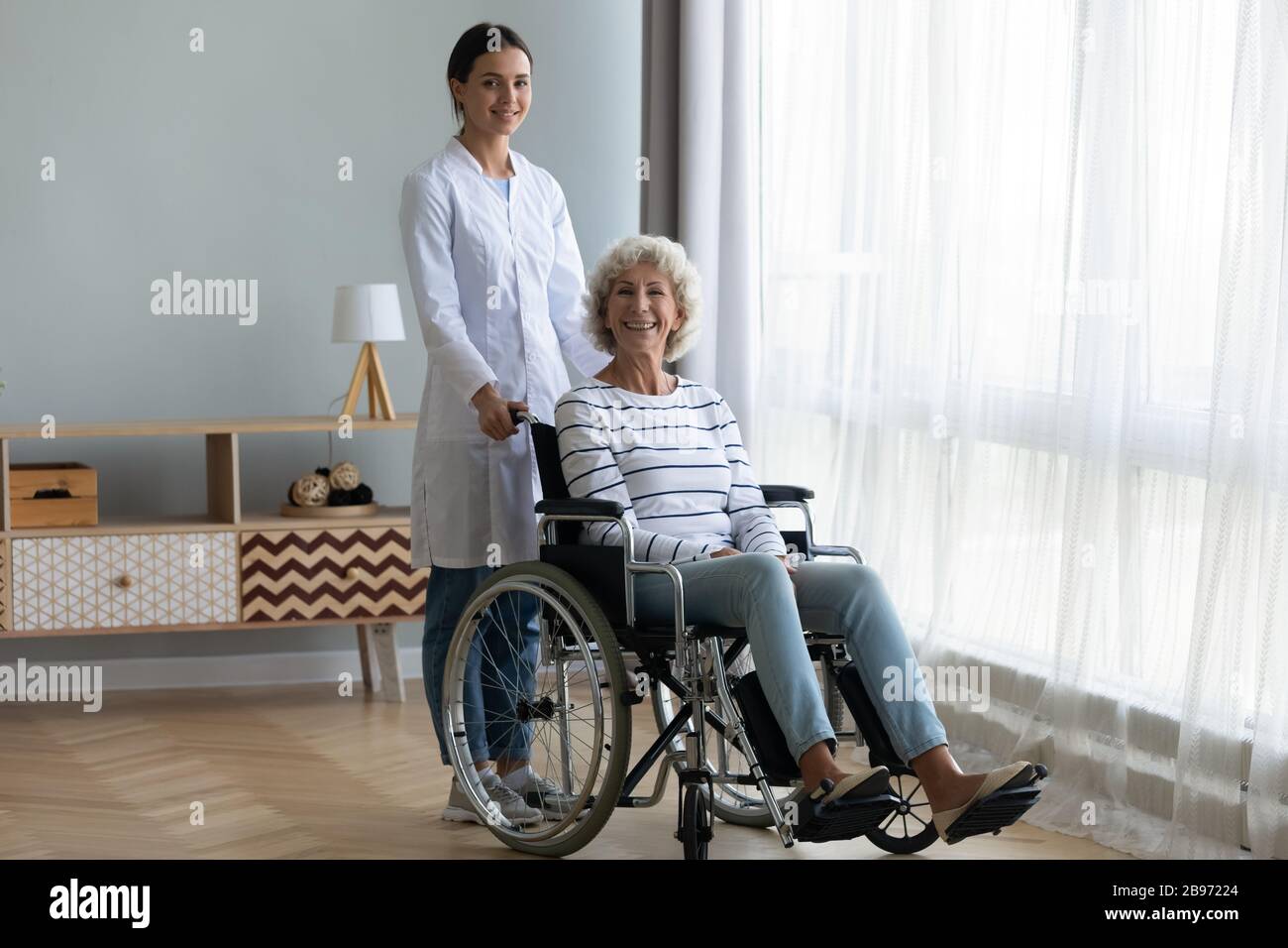 Assistenza infermieristica femminile paziente anziana con disabilità Foto Stock