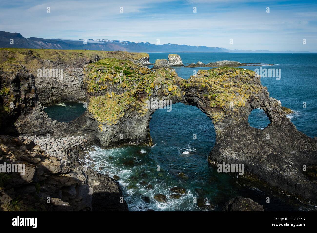 Famoso arco di roccia Gatklettur a Snaefellsnes Islanda costa in giornata di sole con cielo nuvoloso. Nessuna gente visibile, copyspace. Foto Stock