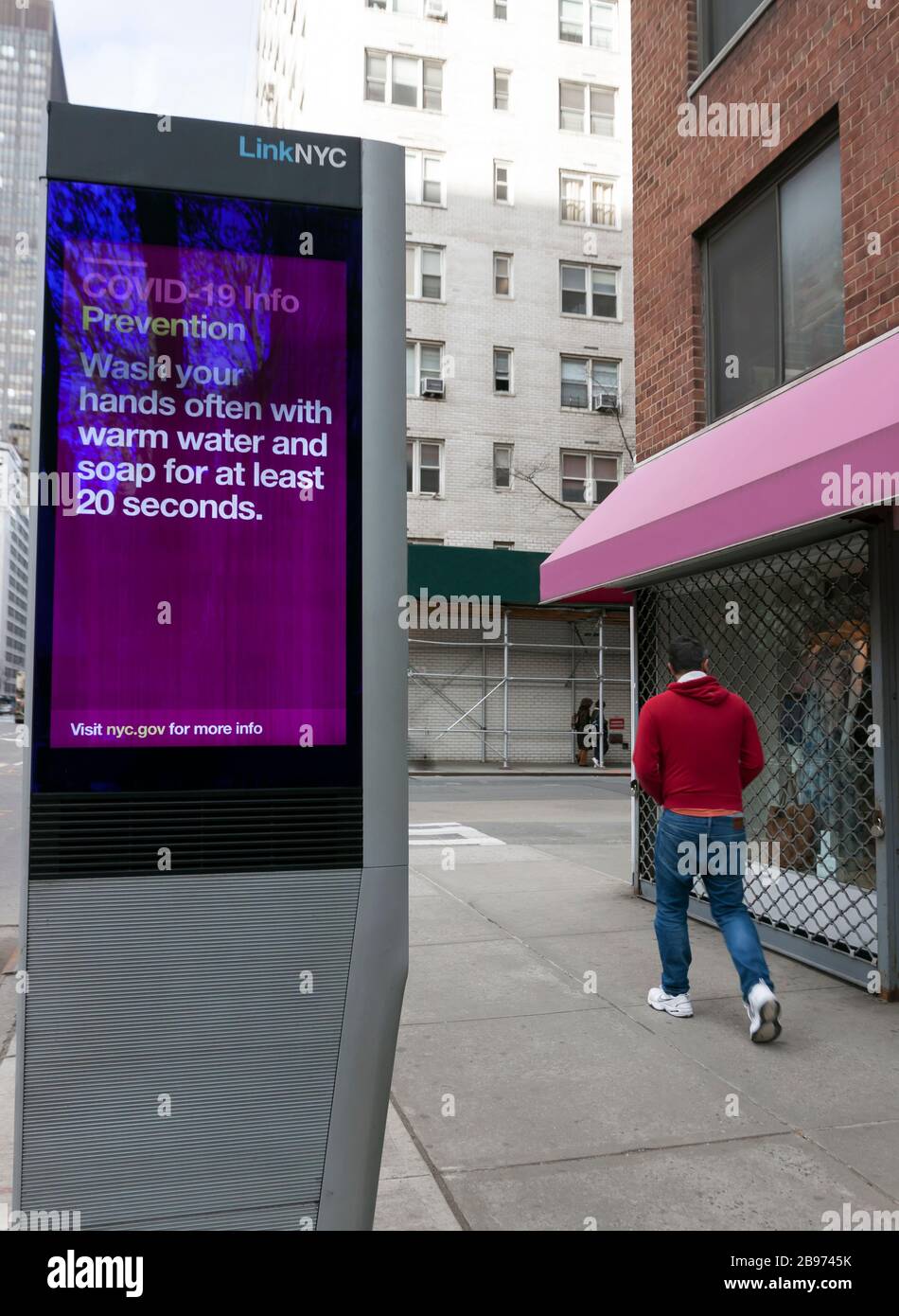 LinkNYC digitale Kiosk segno sul marciapiede che mostra Covid-19 (coronavirus) prevenzione suggerimenti e consigli sul lavaggio a mano a New Yorkers. Foto Stock