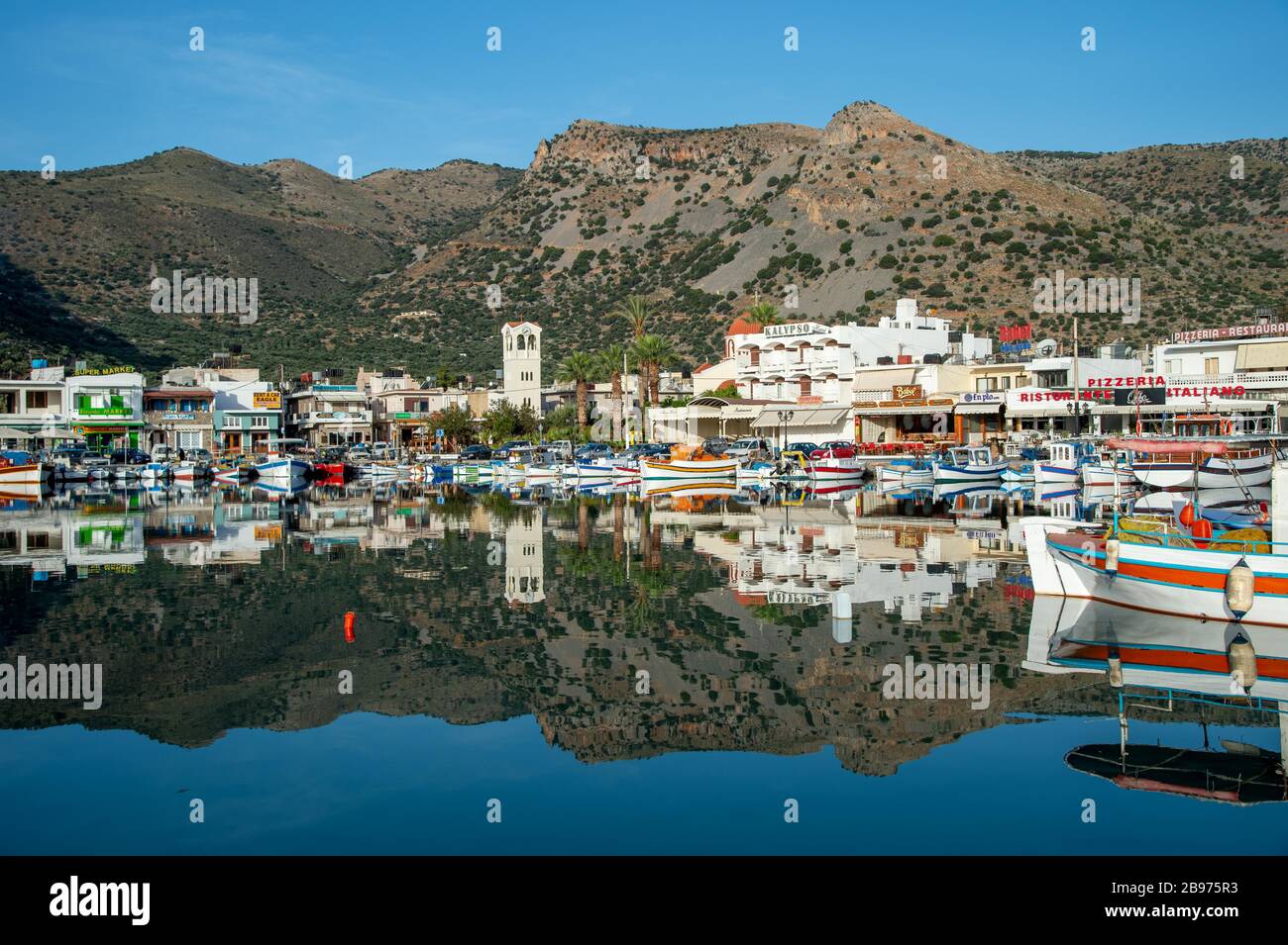 L'ex villaggio di pescatori di Elounda riflette l'acqua; Elounda; Creta; Grecia Foto Stock