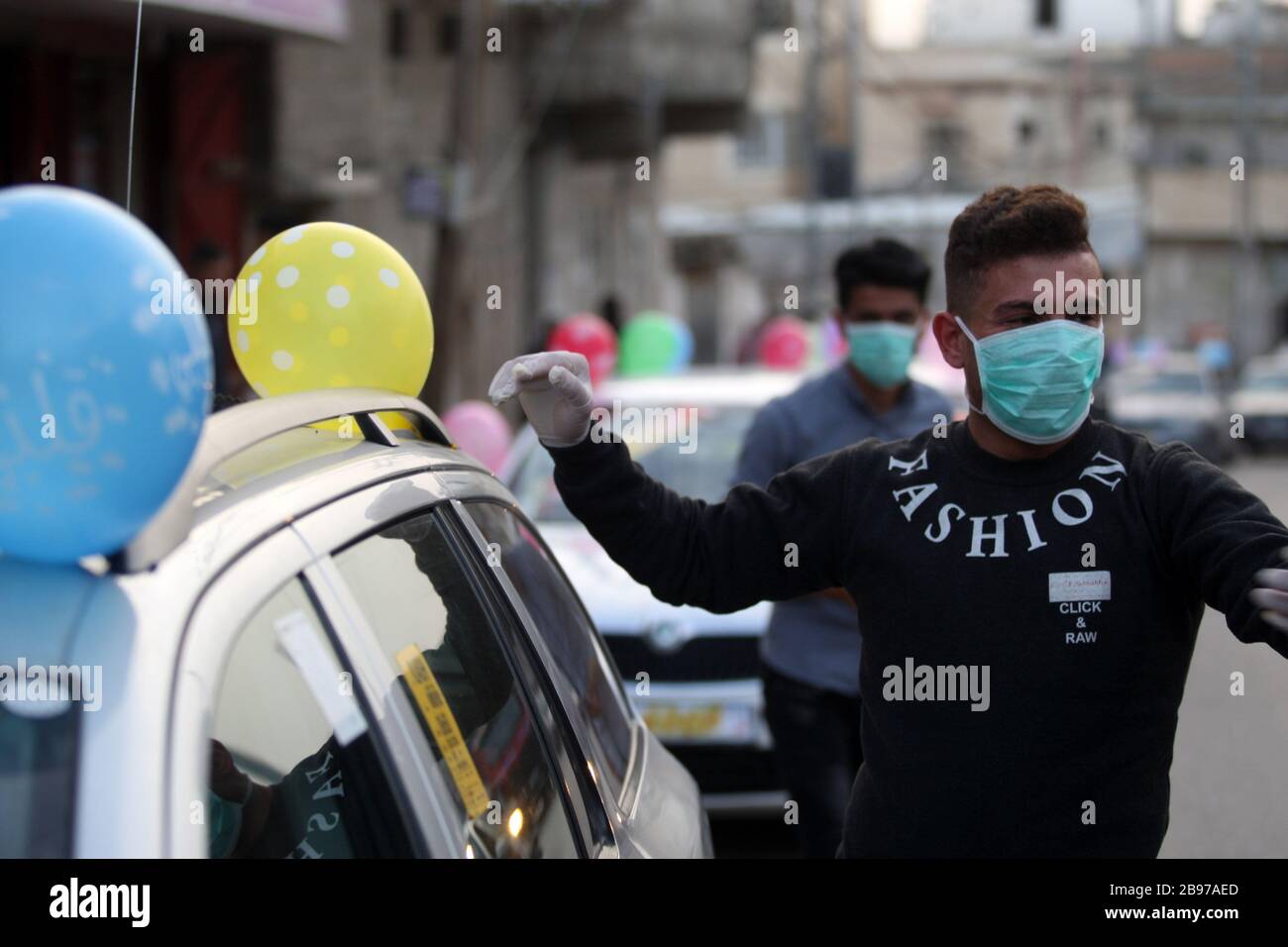 Khan Younis, Gaza. 23 marzo 2020. I parenti dello sposo, Mohamad Abu Daga, che indossano maschere protettive a causa dell'epidemia COVID-19, frequentano un matrimonio a Khan Younis nella striscia meridionale, lunedì 23 marzo 2020. Credito: UPI/Alamy Live News Foto Stock